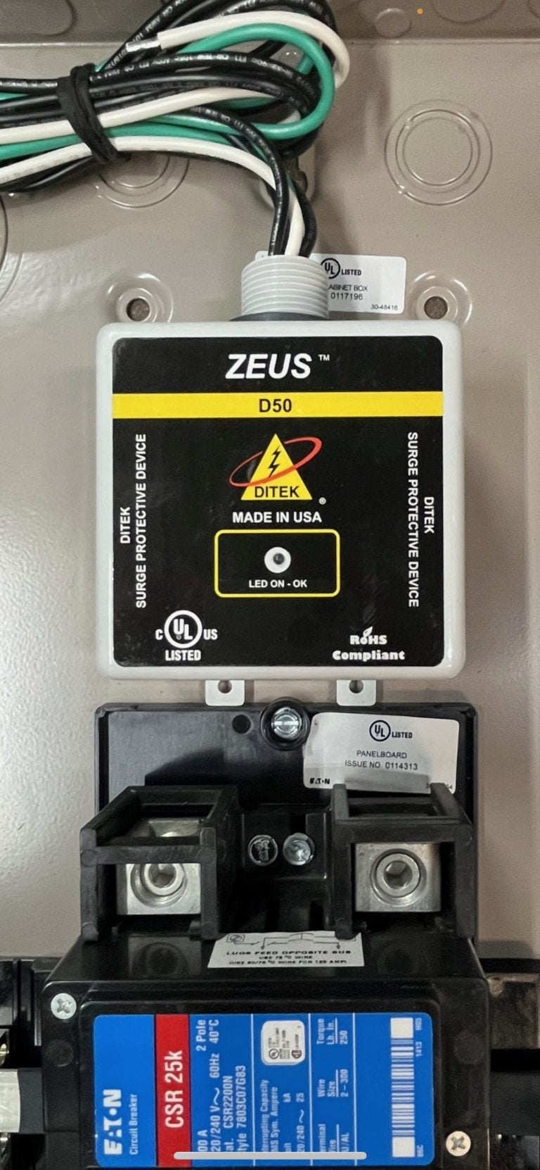 Surge protective device ZEUS D50 by DITEK installed above a circuit breaker in an electrical panel.